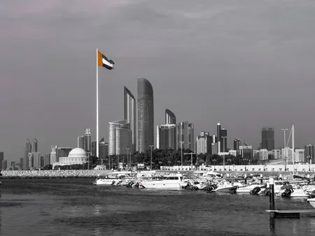 Abu Dhabi skyline with modern skyscrapers and the UAE flag