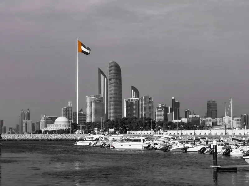 Abu Dhabi skyline with modern towers and the UAE flag