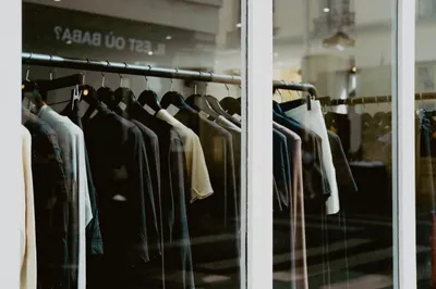 ملابس معلّقة على رفوف في واجهة متجر أزياء